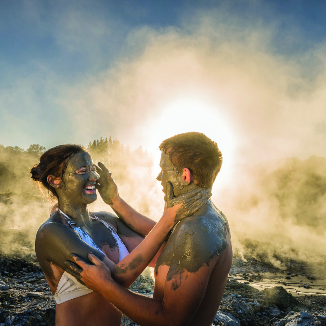 A couple puts mud on each other's face at Hells Gate